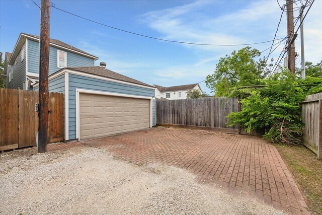 garage featuring fence and driveway