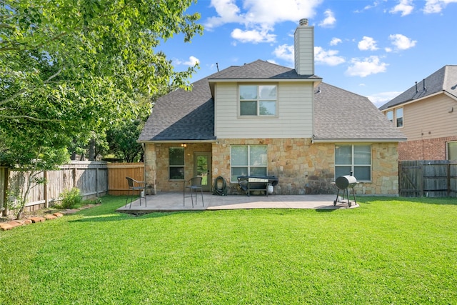 back of property with stone siding, a chimney, a patio, and a shingled roof