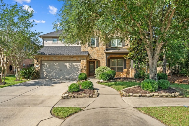 view of front of home featuring stone siding, an attached garage, and driveway