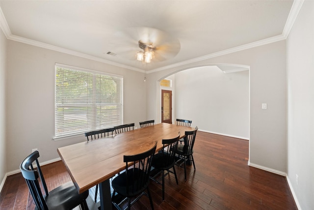dining area featuring arched walkways, hardwood / wood-style flooring, a ceiling fan, ornamental molding, and baseboards