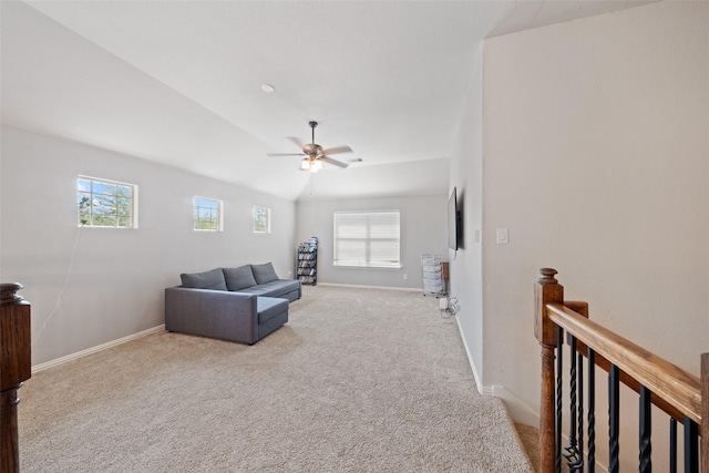 living room featuring light carpet, healthy amount of natural light, baseboards, and vaulted ceiling