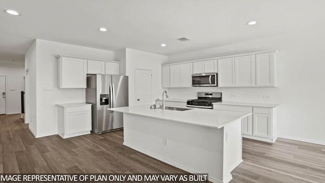 kitchen featuring stainless steel appliances, a sink, dark wood-style flooring, light countertops, and recessed lighting
