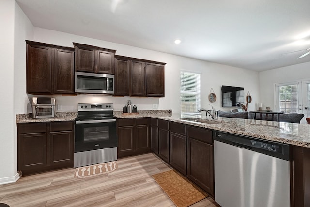 10707 Lost Maples Dr, Cleveland, TX 77328 - kitchen with appliances with stainless steel finishes, a sink, plenty of natural light, light wood finished floors, and recessed lighting