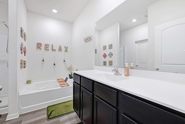 10707 Lost Maples Dr, Cleveland, TX 77328 - full bath featuring a shower stall, wood finished floors, a garden tub, vanity, and recessed lighting