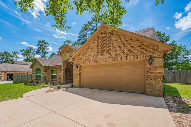 503 Weisinger Dr, Magnolia, TX 77354 - view of front facade with concrete driveway, an attached garage, brick siding, and stone siding