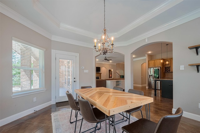 503 Weisinger Dr, Magnolia, TX 77354 - dining space with arched walkways, ornamental molding, a chandelier, a raised ceiling, and baseboards