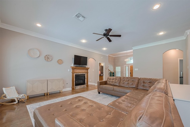 503 Weisinger Dr, Magnolia, TX 77354 - living room featuring arched walkways, recessed lighting, a ceiling fan, a glass covered fireplace, and ornamental molding