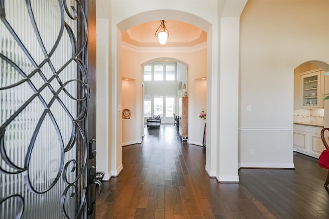 23615 Dolci Ln, Richmond, TX 77406 - foyer entrance featuring dark wood-style floors, crown molding, a towering ceiling, baseboards, and arched walkways