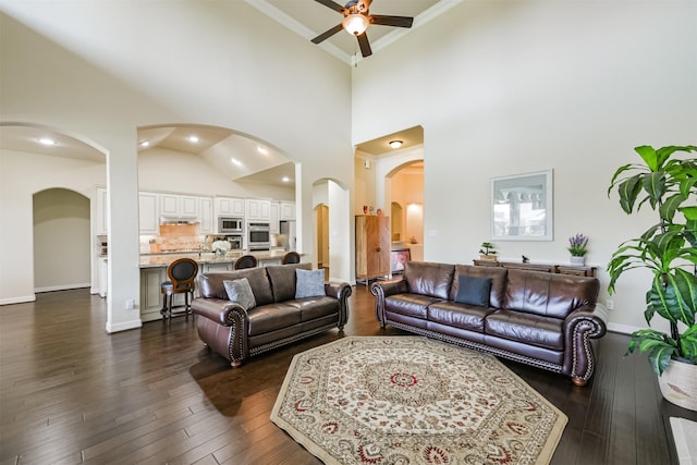23615 Dolci Ln, Richmond, TX 77406 - living room with arched walkways, ceiling fan, crown molding, a high ceiling, and dark wood-type flooring