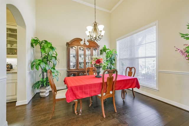 23615 Dolci Ln, Richmond, TX 77406 - dining area featuring crown molding, a chandelier, dark wood-style flooring, a towering ceiling, and baseboards