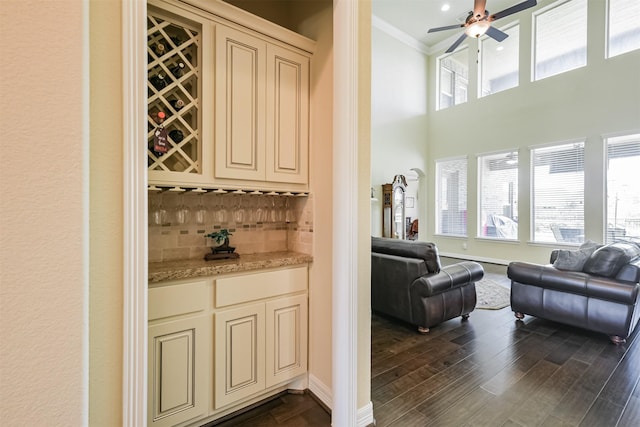 23615 Dolci Ln, Richmond, TX 77406 - indoor bar with crown molding, tasteful backsplash, ceiling fan, a high ceiling, and baseboards