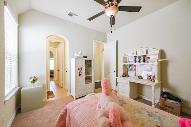 23615 Dolci Ln, Richmond, TX 77406 - bedroom featuring arched walkways, multiple windows, light carpet, lofted ceiling, and ceiling fan