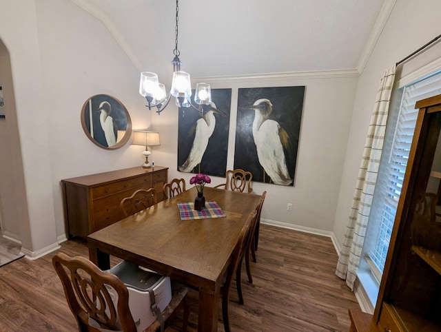 dining room featuring vaulted ceiling, wood finished floors, a chandelier, baseboards, and crown molding