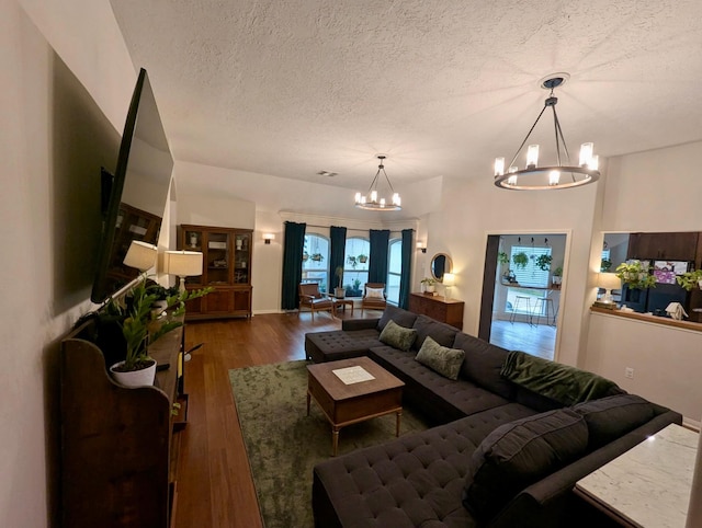 living area with a chandelier, a textured ceiling, and wood finished floors