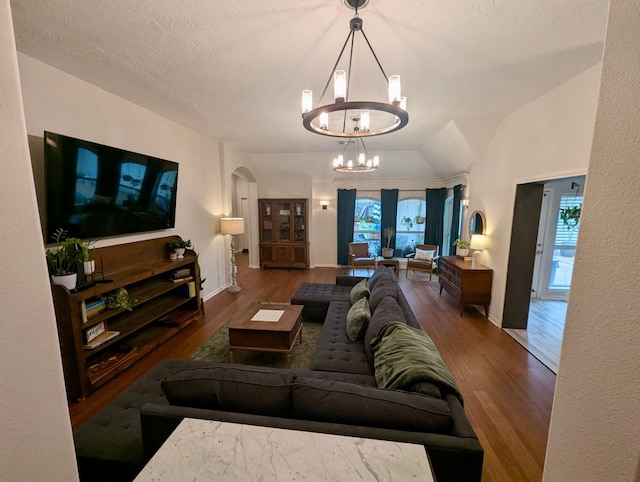 living area with a chandelier, wood finished floors, arched walkways, and baseboards