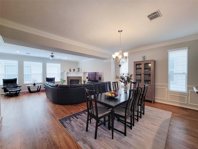 1241 Prince St, Houston, TX 77008 - dining room featuring a fireplace, wood finished floors, a chandelier, healthy amount of natural light, and ornamental molding