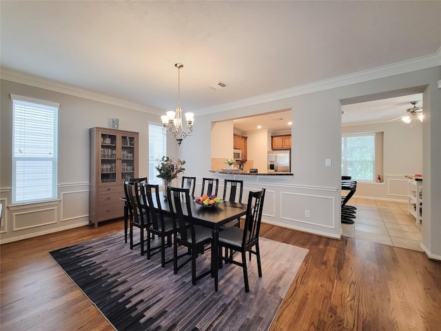 1241 Prince St, Houston, TX 77008 - dining room with a chandelier, a decorative wall, ornamental molding, wood finished floors, and a wainscoted wall