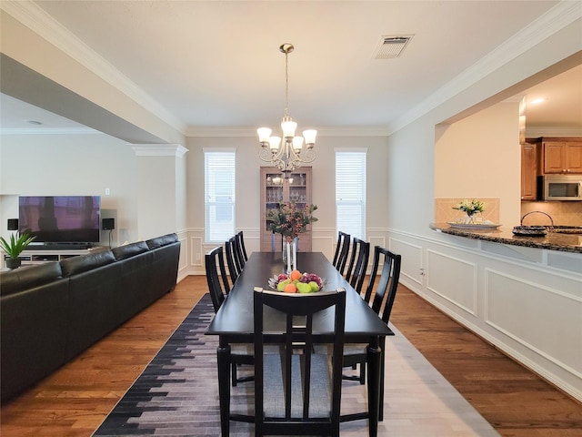 1241 Prince St, Houston, TX 77008 - dining room featuring a chandelier, a decorative wall, wood finished floors, and ornamental molding