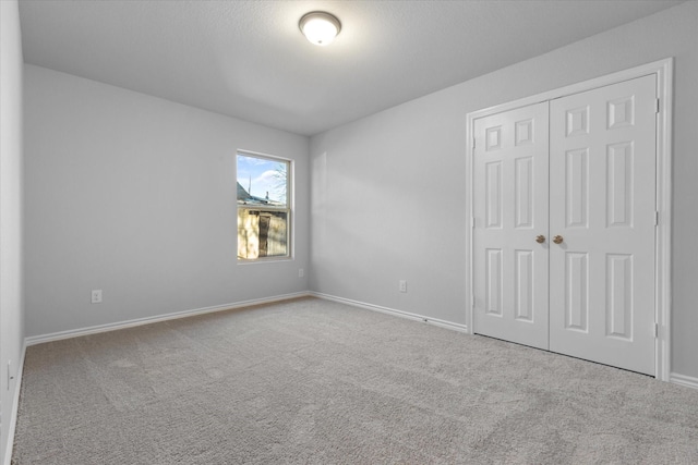 unfurnished bedroom featuring carpet floors, a closet, and baseboards