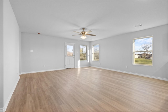 spare room featuring ceiling fan, light wood-style floors, and baseboards
