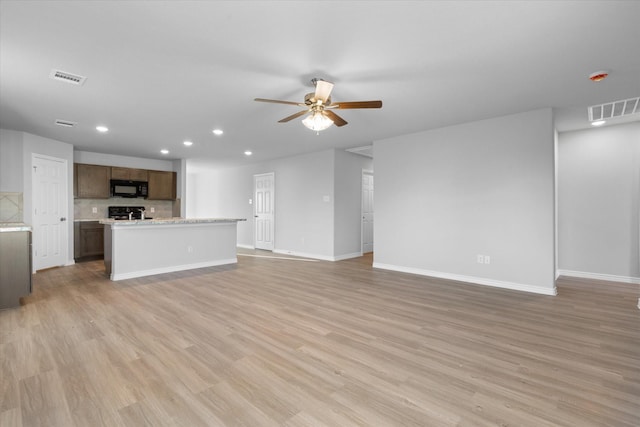 unfurnished living room featuring recessed lighting, a ceiling fan, baseboards, and light wood-style flooring