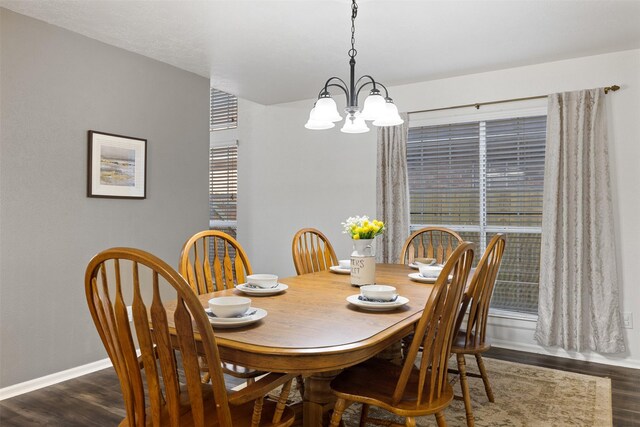 dining space with a chandelier, dark wood-style floors, and baseboards