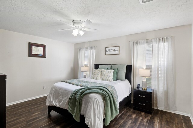 bedroom with dark wood finished floors, baseboards, a ceiling fan, and a textured ceiling