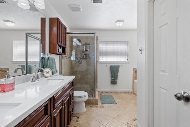 full bath with plenty of natural light, a stall shower, tile patterned flooring, and a textured ceiling