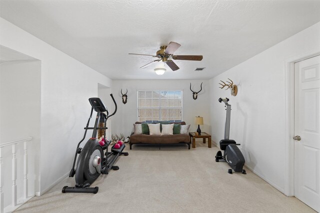 exercise area with carpet floors, ceiling fan, and baseboards