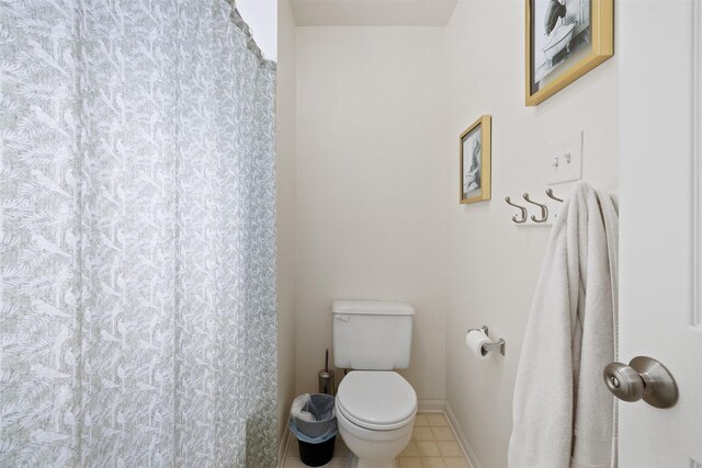 full bath with toilet, baseboards, and a shower with shower curtain