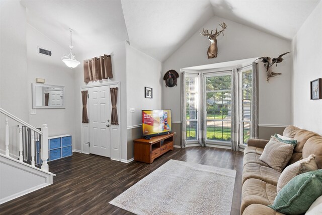 living area featuring dark wood finished floors, high vaulted ceiling, stairs, and baseboards