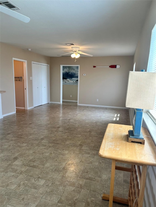 3913 1st, Galveston, TX 77554 - unfurnished living room with a ceiling fan, baseboards, and stone finish floors