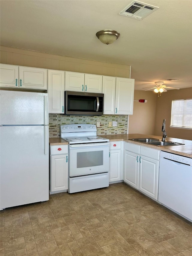 3913 1st, Galveston, TX 77554 - kitchen with white appliances, a sink, decorative backsplash, and white cabinets