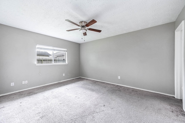 carpeted empty room featuring a ceiling fan, a textured ceiling, and baseboards