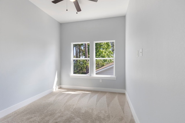 carpeted spare room with ceiling fan and baseboards
