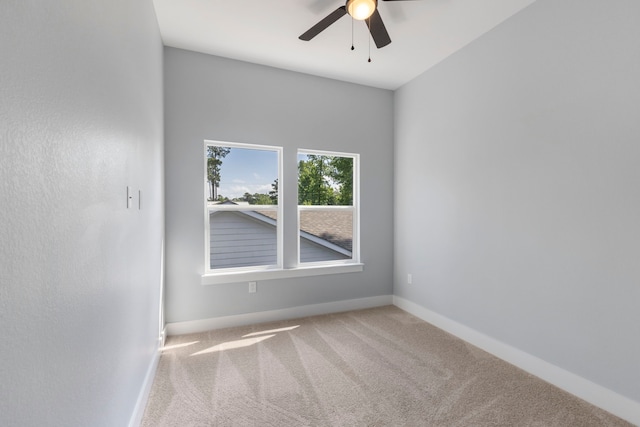 spare room with carpet, a ceiling fan, and baseboards