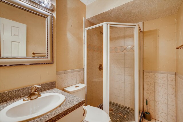 11104 Timber Crest Dr, Houston, TX 77065 - bathroom featuring a shower stall, tile walls, toilet, vanity, and wainscoting