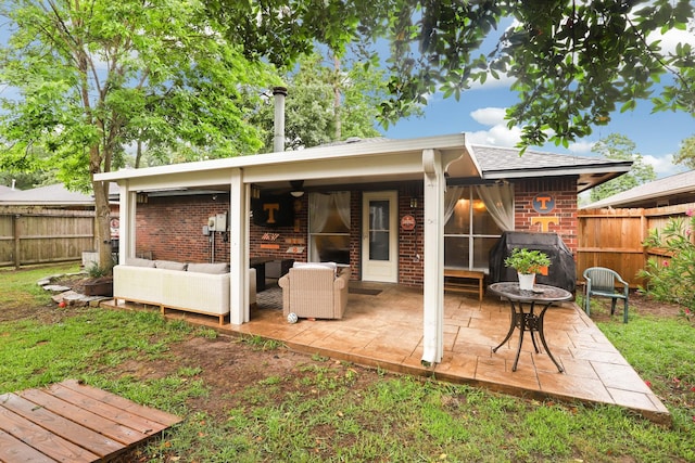 back of house featuring a fenced backyard, brick siding, an outdoor hangout area, and a patio