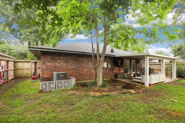 rear view of house featuring an outdoor living space, brick siding, central air condition unit, and roof with shingles