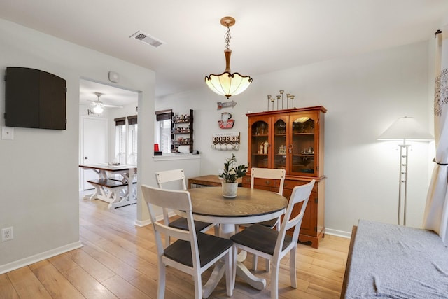 dining area featuring ceiling fan, light wood-style flooring, and baseboards