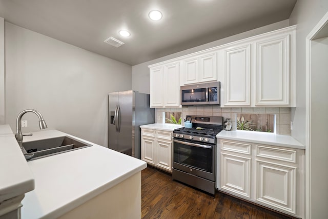 kitchen featuring stainless steel appliances, a sink, backsplash, dark wood-style floors, and recessed lighting
