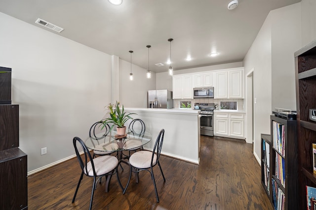dining room featuring dark wood-style flooring and baseboards