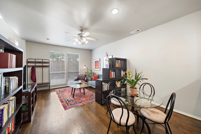 dining room with ceiling fan, dark wood-type flooring, and baseboards