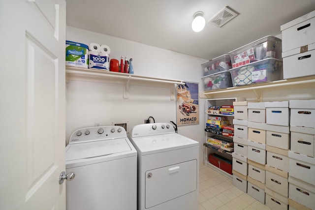 laundry room featuring separate washer and dryer and light tile patterned floors