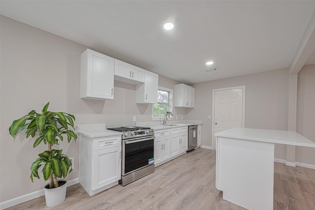 7702 Darnay Dr, Houston, TX 77033 - kitchen with appliances with stainless steel finishes, a sink, light countertops, light wood-style flooring, and recessed lighting