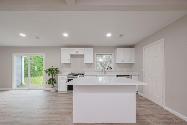 7702 Darnay Dr, Houston, TX 77033 - kitchen with appliances with stainless steel finishes, a center island, light wood-style floors, light countertops, and baseboards