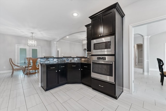 929 Oak St, Houston, TX 77018 - kitchen featuring decorative columns, appliances with stainless steel finishes, arched walkways, tasteful backsplash, and recessed lighting