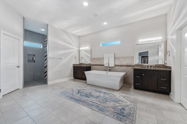 929 Oak St, Houston, TX 77018 - full bath featuring tile patterned floors, a freestanding bath, two vanities, and recessed lighting