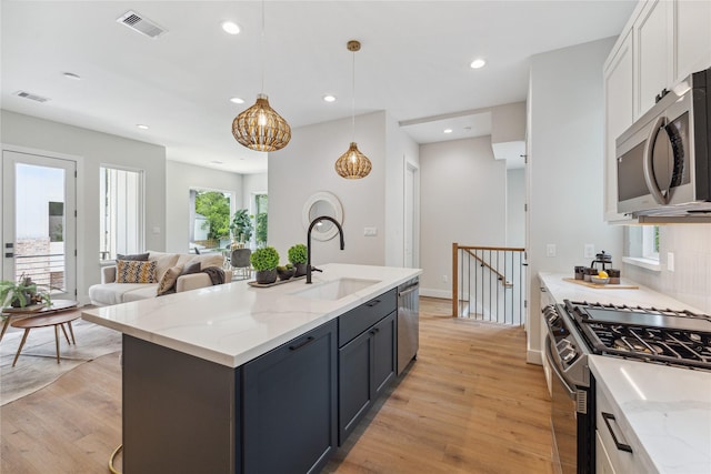 514 Janisch Rd, Houston, TX 77018 - kitchen with stainless steel appliances, a sink, light wood-style flooring, white cabinetry, and recessed lighting