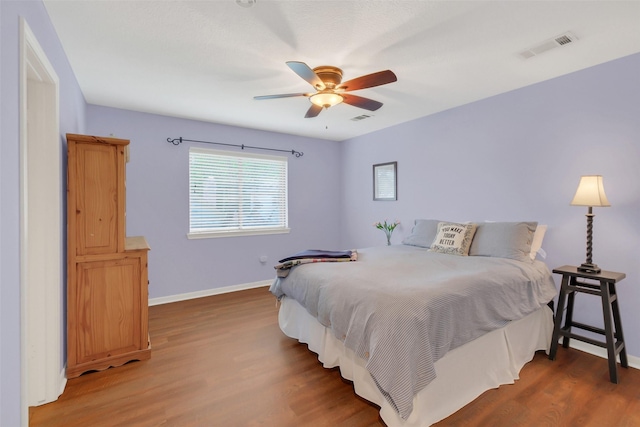 bedroom with baseboards, wood finished floors, and ceiling fan